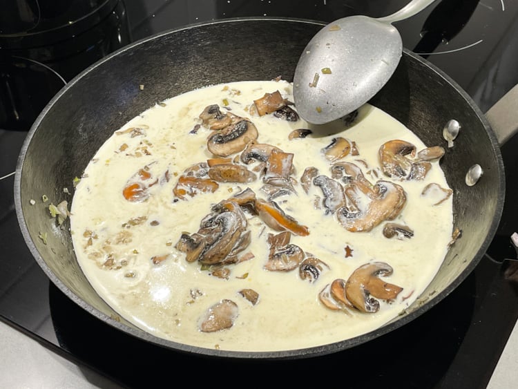 svamp, grädde, lök och kryddor i stekpanna