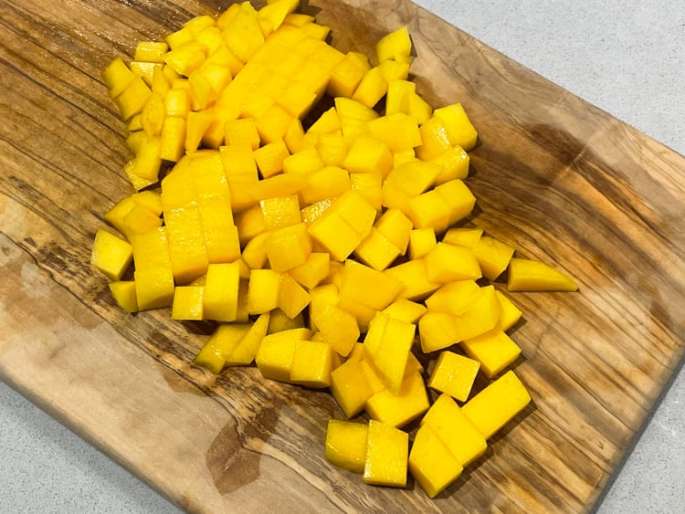 tärnad mango på skärbräda