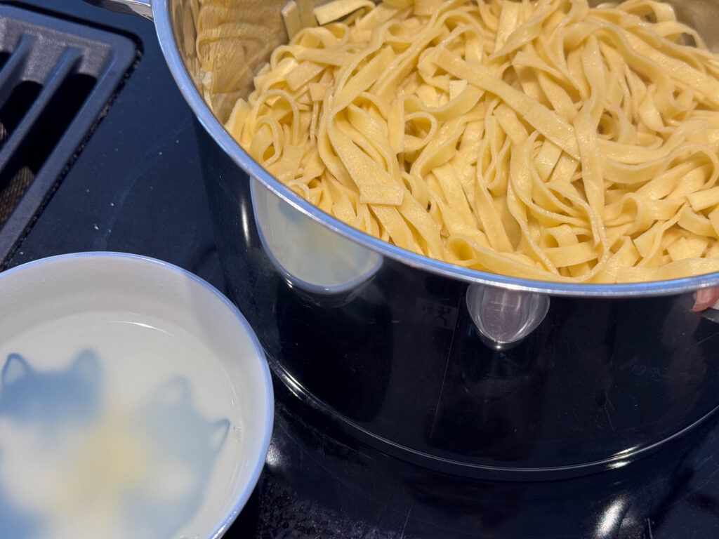 färdigkokt pasta och pastavatten i skål